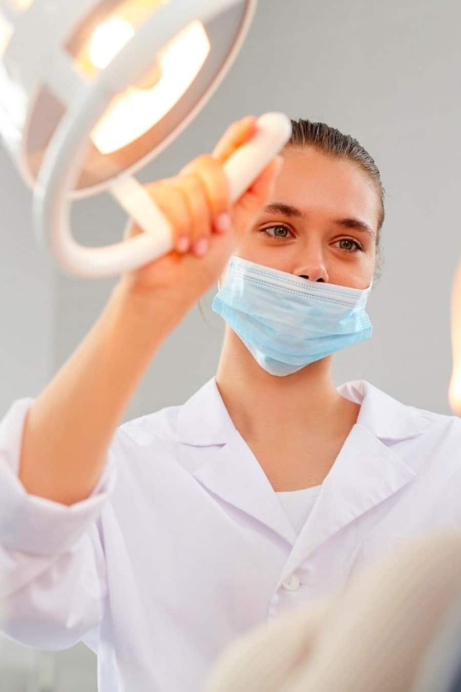 dentista-acercando-luz-a-paciente clínica dental amara