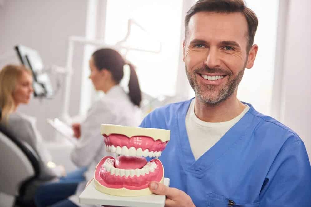 dentista sonriente mostrando dentadura protesiss