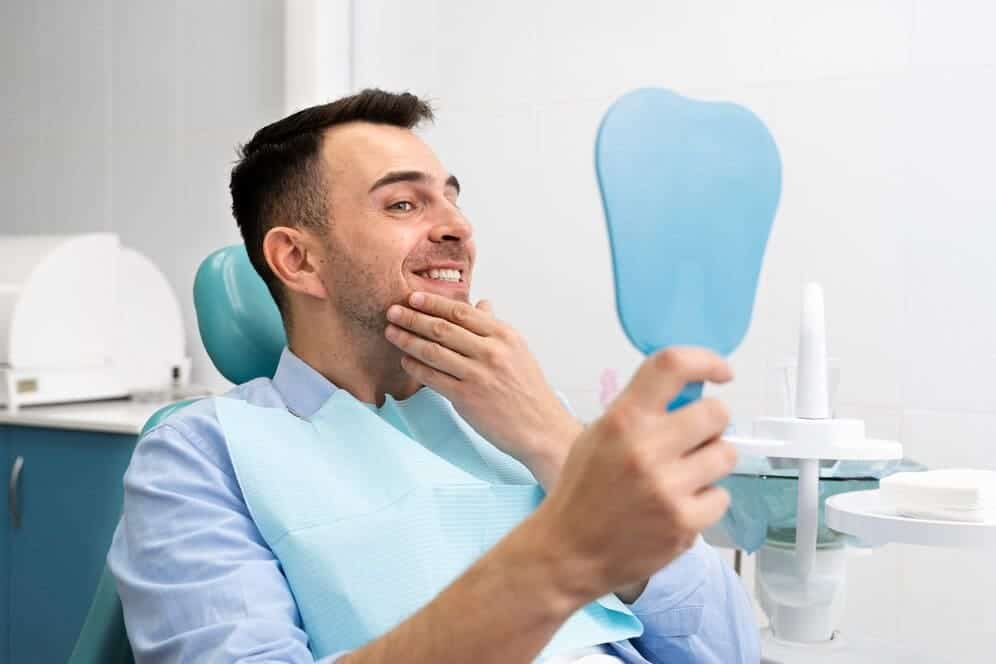hombre feliz espejo dentista sonrisa blanca